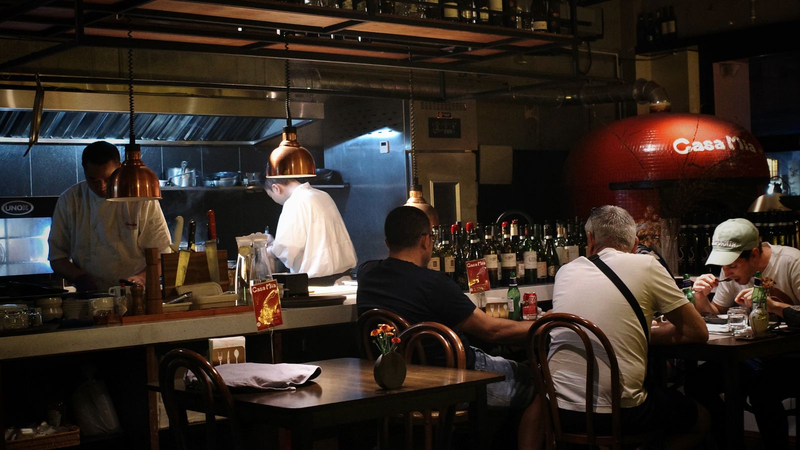 Warm, lively dining room at an open-kitchen restaurant