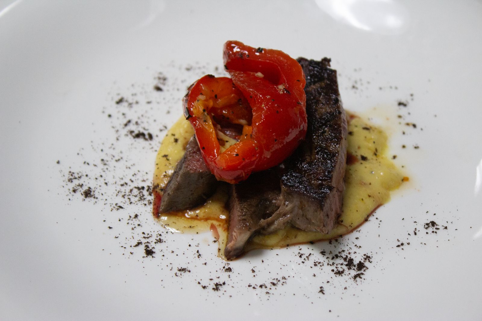 Live-fire steak plated with seasonal vegetables